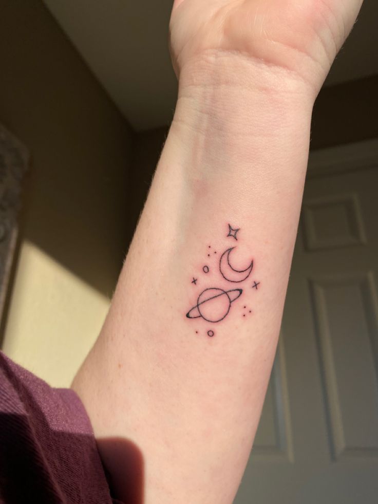 a woman's arm with a tattoo on it that has stars and crescents