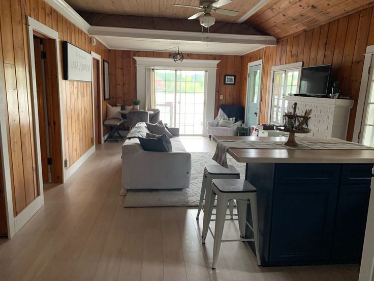 a living room filled with furniture next to a kitchen