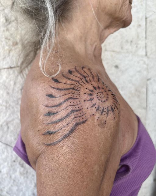 an older woman with a tattoo on her back