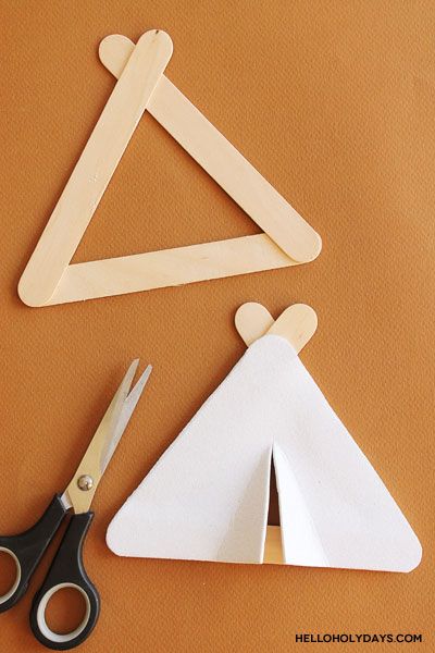 two pieces of wood cut out to look like triangle shapes with scissors on the side