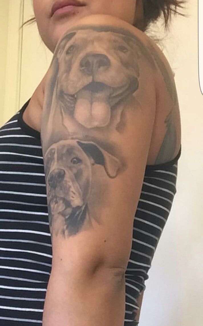 a woman with a dog tattoo on her arm and shoulder is looking at the camera