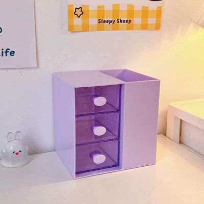 a purple box sitting on top of a white table next to a stuffed bunny toy