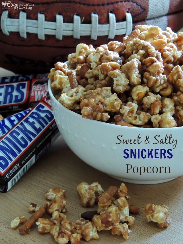 sweet and salty snickkers popcorn in a white bowl with football on the side