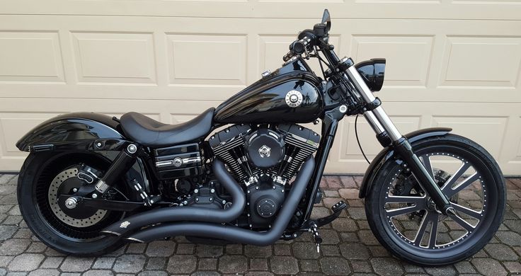 a black motorcycle parked in front of a garage door