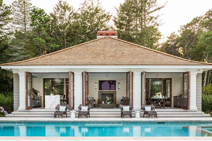 a pool house with chairs around it