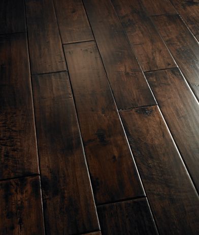 a wooden floor with dark wood floors and white trimming on the top half of it