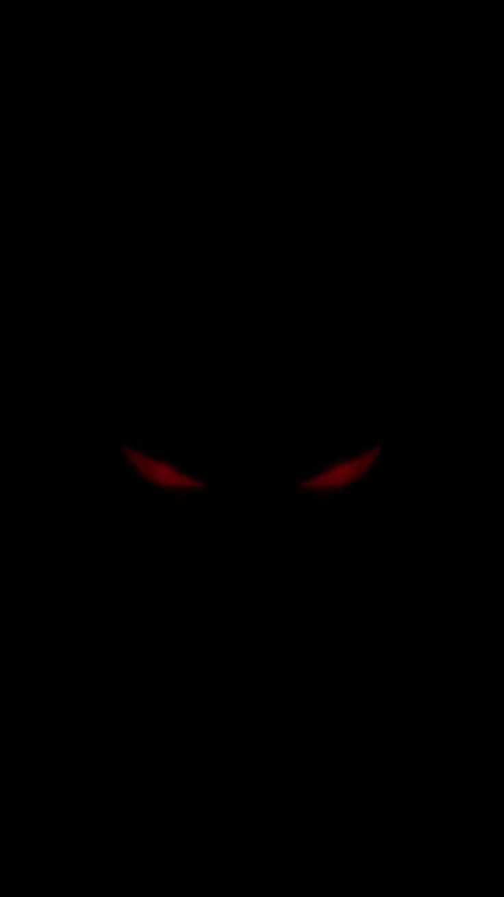 an evil face in the dark with red eyes