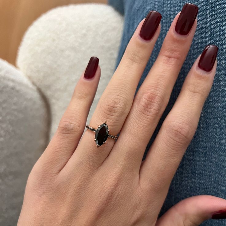 a woman's hand with red manicures and a ring on her finger