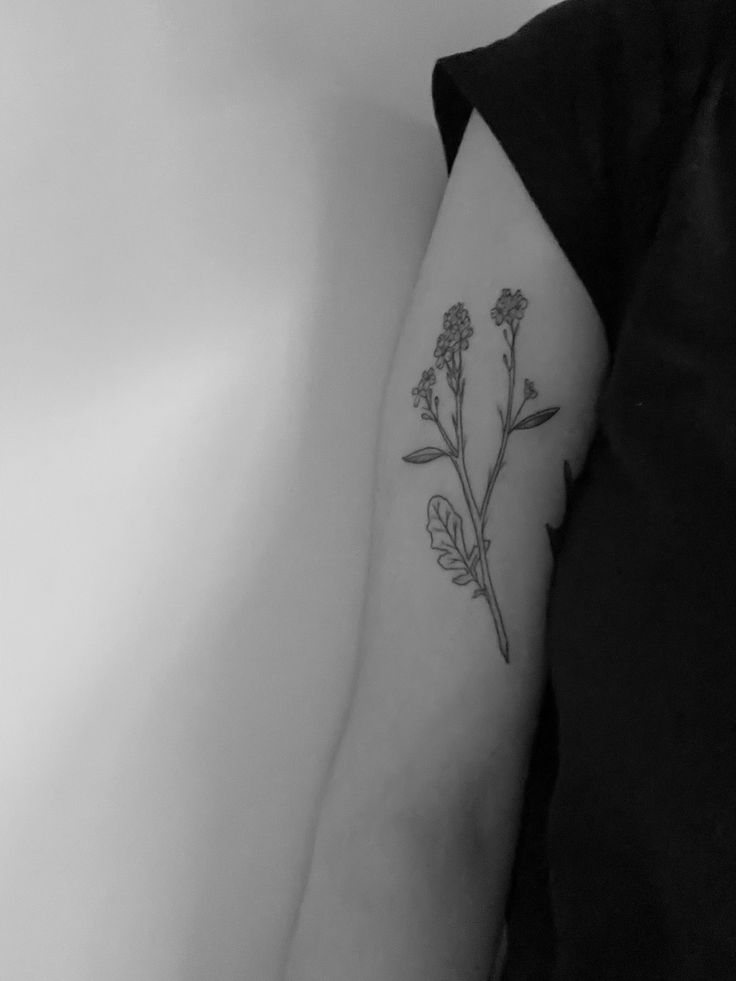 a black and white photo of a flower on the arm