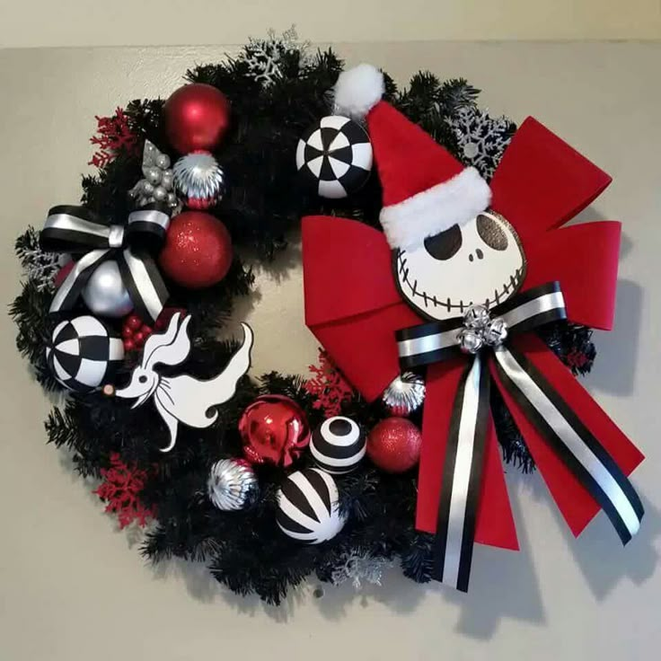 a wreath decorated with ornaments and decorations on top of a white wall, in the shape of a skeleton