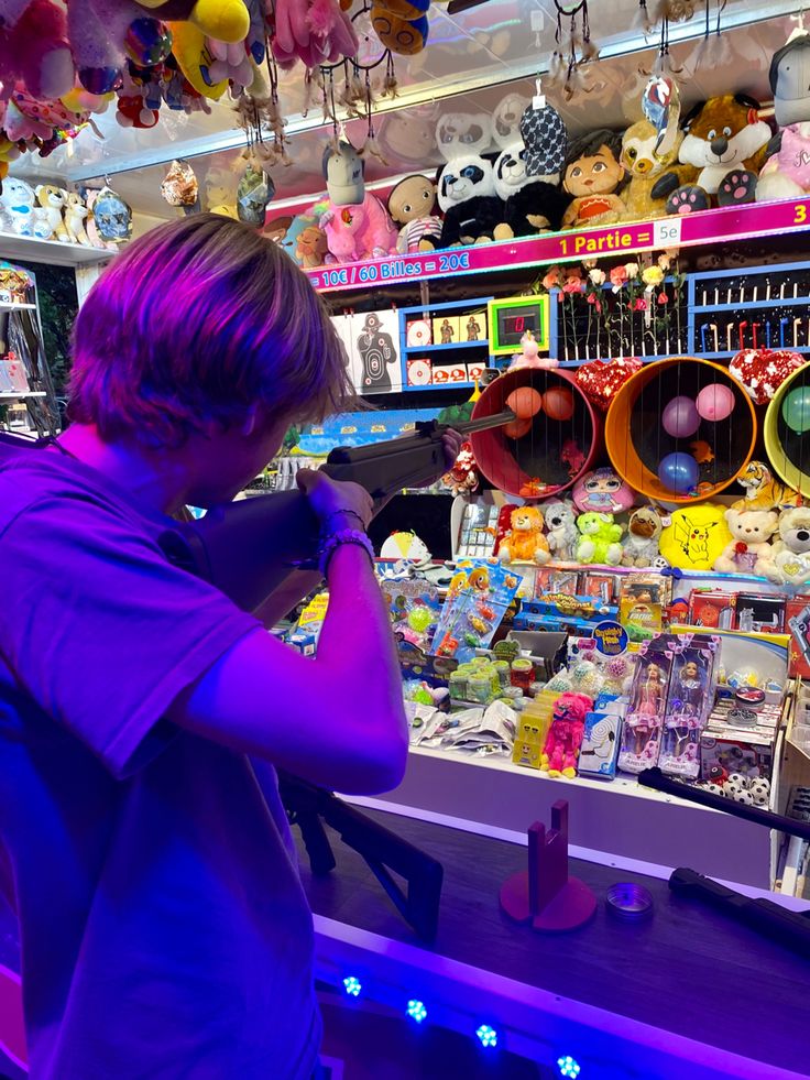 a man standing in front of a store filled with stuffed animals and other stuff items