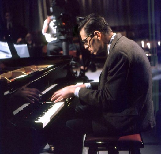 a man sitting at a piano playing music