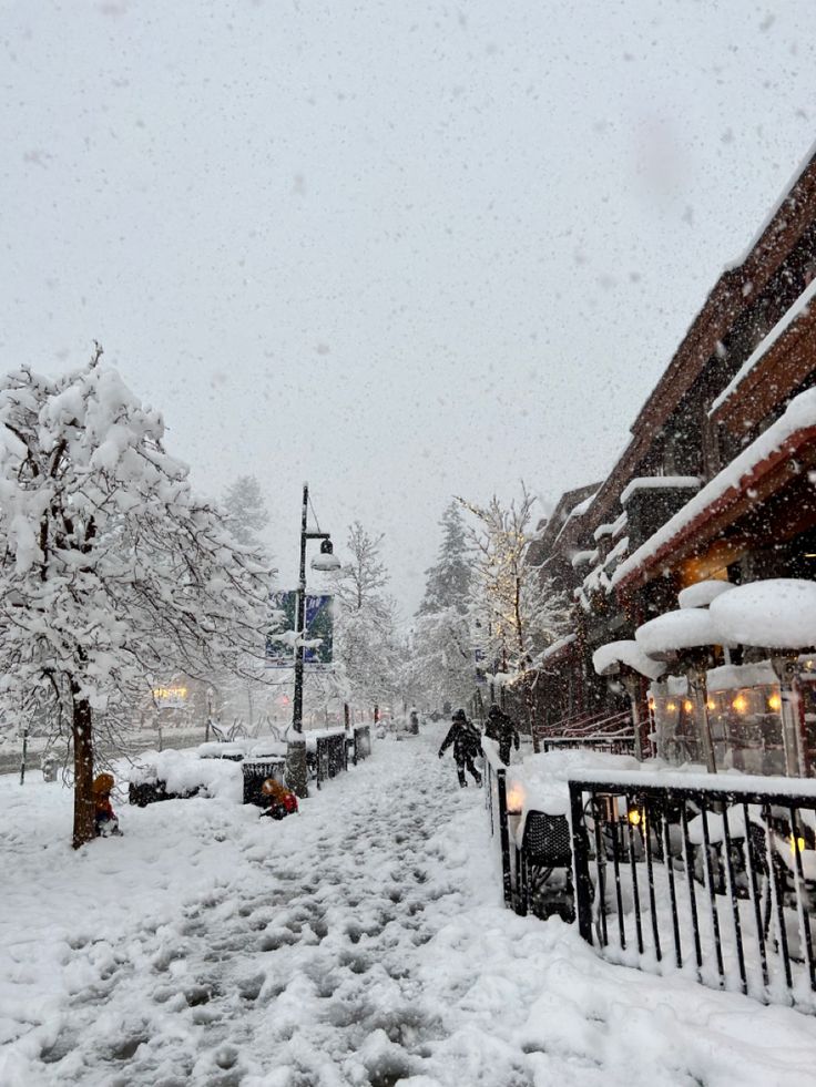 a snowy street with people walking on it