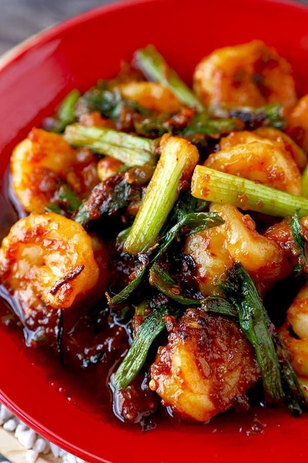 a red plate topped with shrimp and asparagus