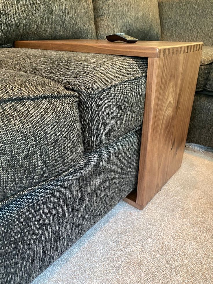 a close up of a couch with a wooden arm rest