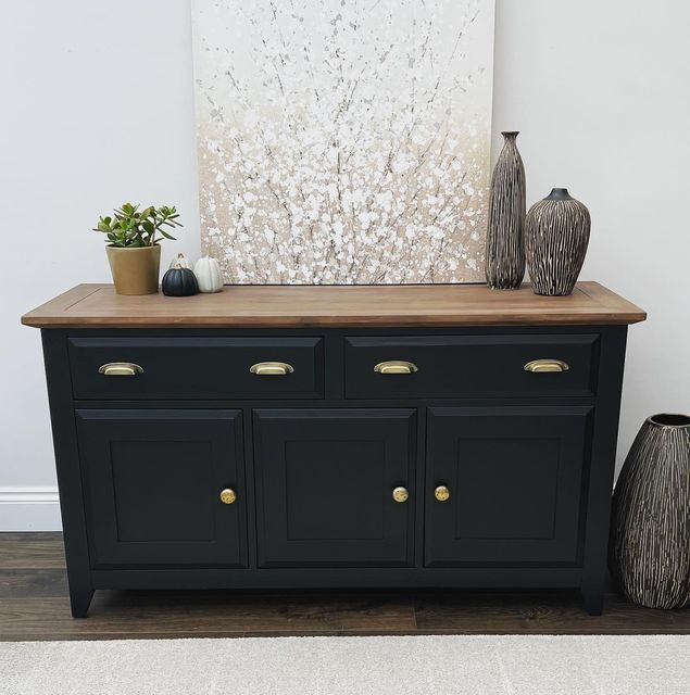 two vases are sitting on top of a black dresser