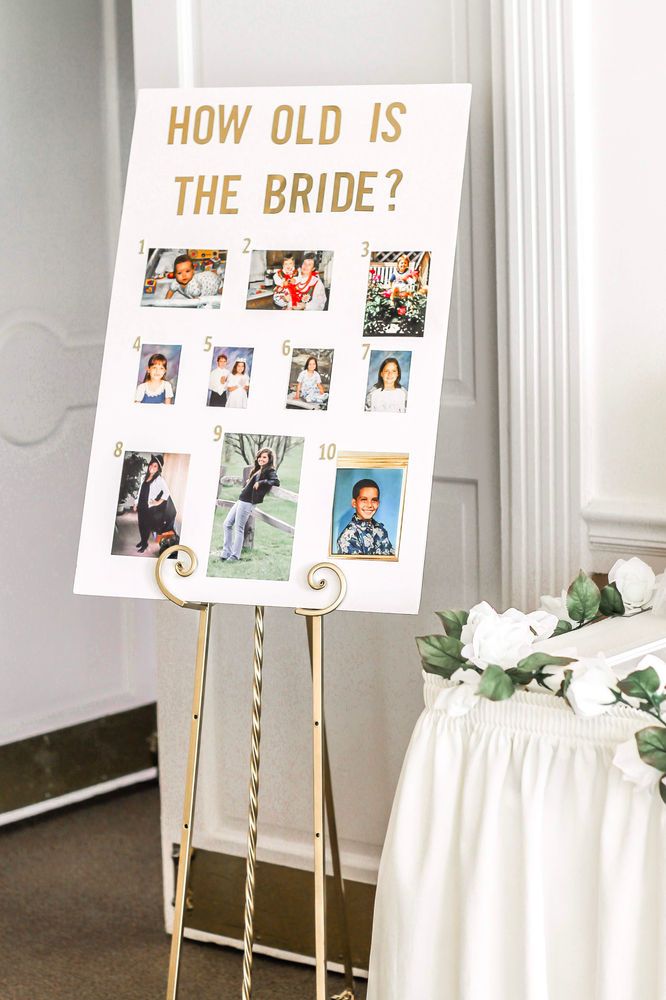 a sign with pictures on it sitting next to a white table cloth and flower arrangement