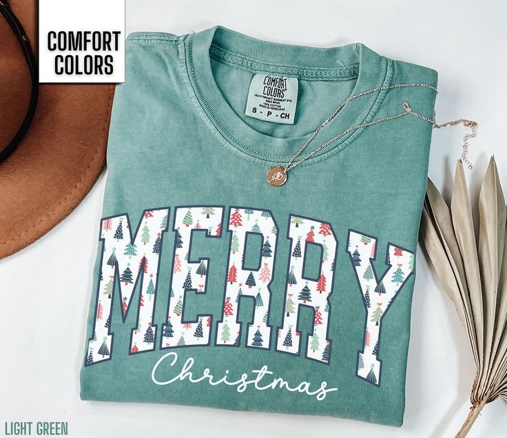 You will love this Merry Christmas shirt for women.  It says Merry in a beautiful Christmas tree font along with Christmas in a script font. This will be the perfect shirt for any woman to wear this holiday season.  Share your Christmas cheer with others this winter. Find our long sleeve tee and crewneck sweatshirts here: Short Sleeve Tee: https://etsy.me/4dGGUaR Long Sleeve Tee: https://etsy.me/3U0W2sW Crewneck Sweatshirt: https://etsy.me/4dxXqKl Comfort Colors T shirt Details: 100% ring-spun c Christmas Shirt For Women, Christmas Green T-shirt With Letter Print, Green Christmas T-shirt With Letter Print, Holiday Green T-shirt With Letter Print, Winter T Shirt, Homemade Shirts, Christmas Shirts For Women, Diy Shirts, Winter T Shirts