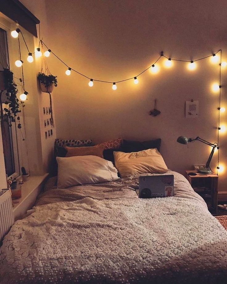 a bedroom with lights strung above the bed