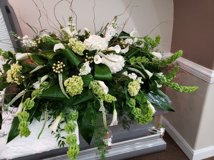 a bouquet of flowers sitting on top of a table next to a mirror in a room