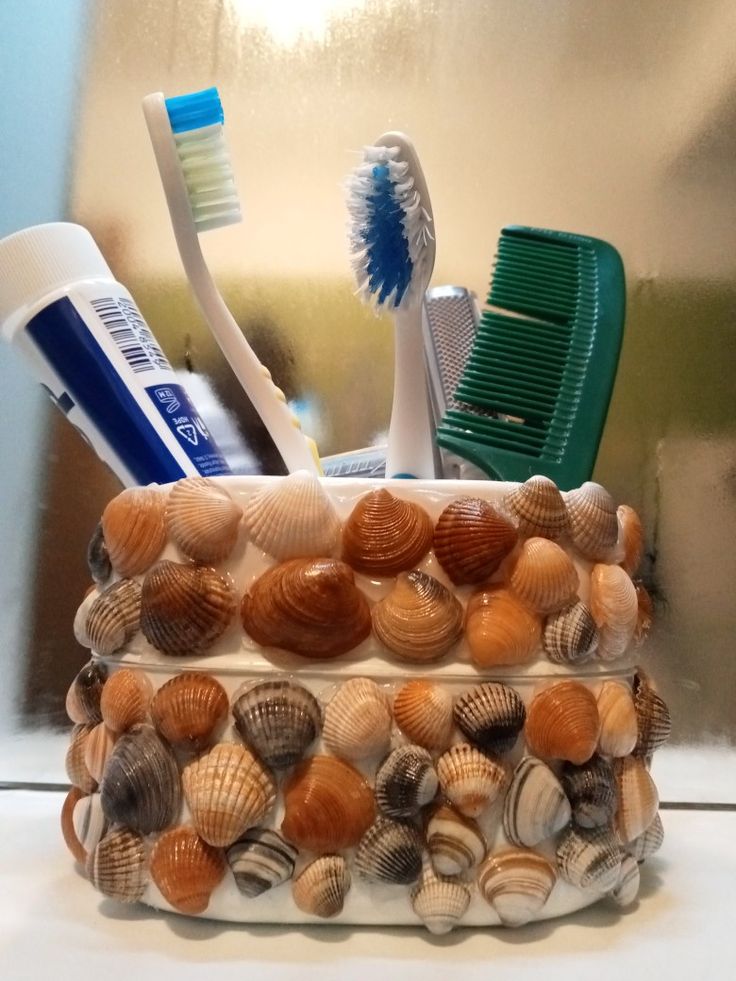 there is a container with shells and toothbrushes in it