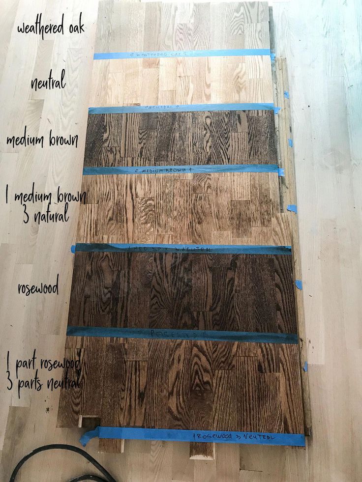 wood flooring being laid out on top of a hard wood floor with blue tape