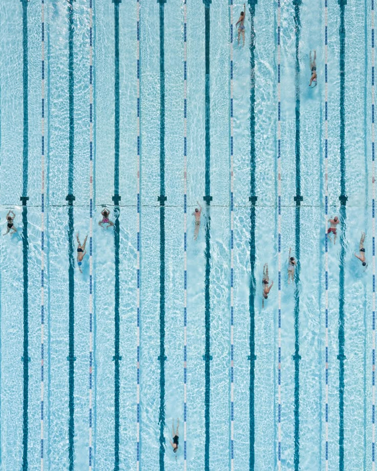 an overhead view of people swimming in a pool with no one on the sidelines