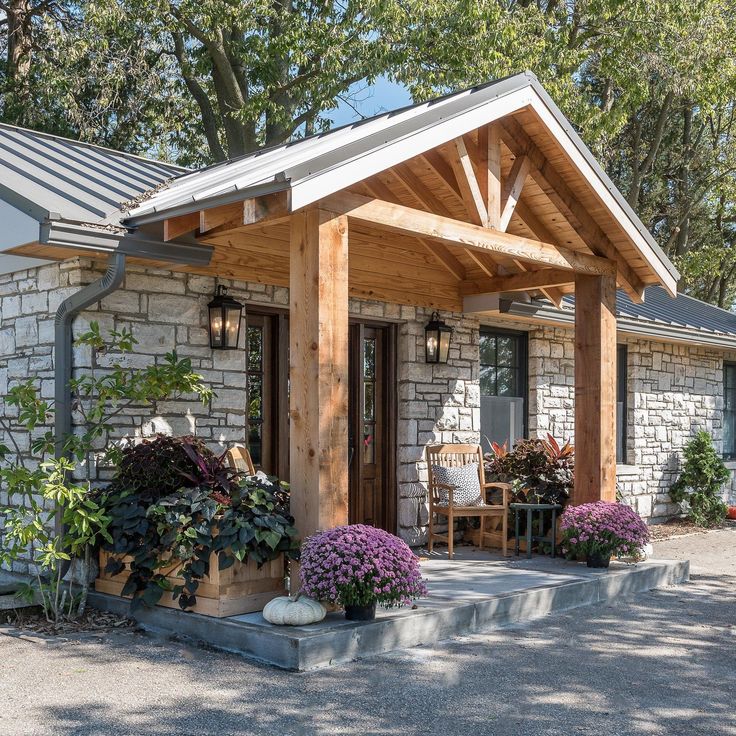 the front entrance to a home with flowers and potted plants