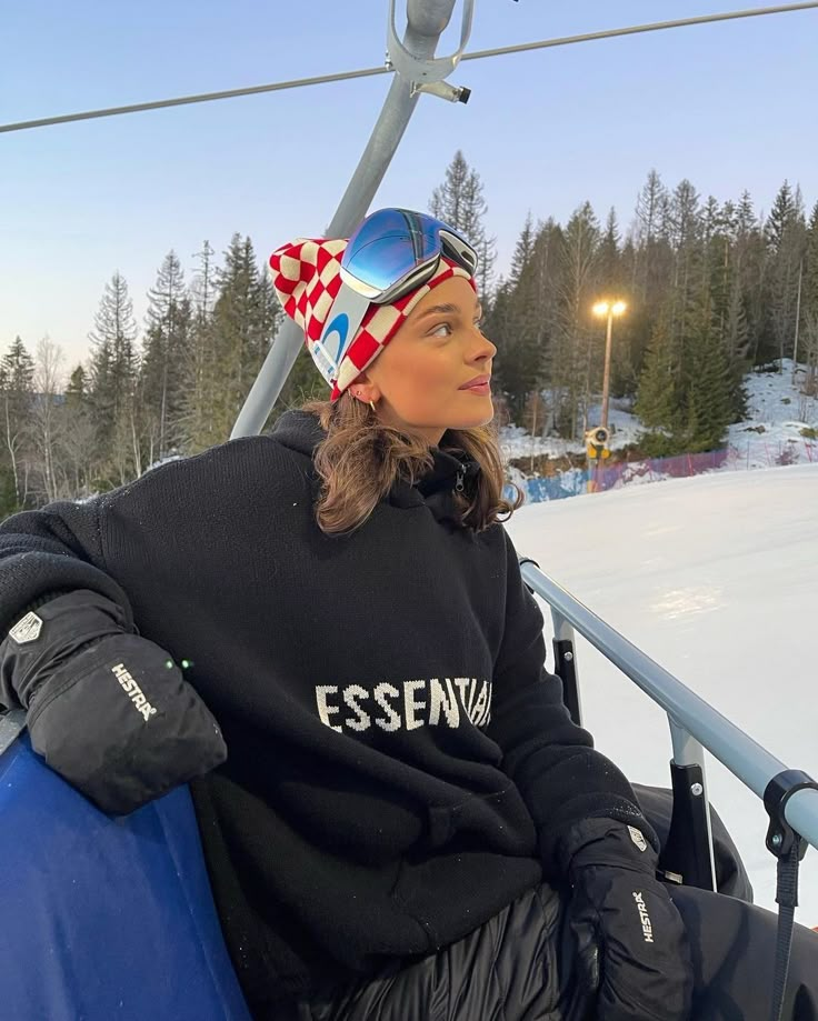 a woman sitting on top of a ski lift