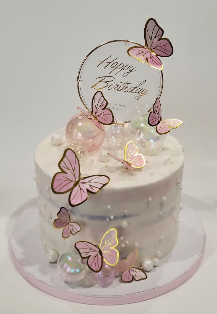 a white cake with pink butterflies on it