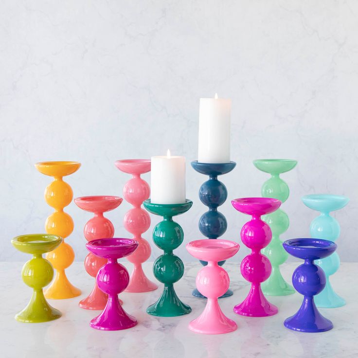 a group of colorful candles sitting next to each other on top of a white table