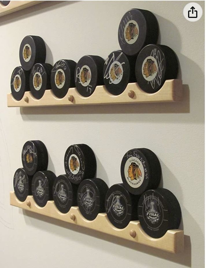 two wooden shelves with hockey pucks on them and one is displaying the same team's logo