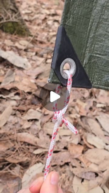 a person holding a piece of paper with scissors attached to it in their hand while standing on the ground