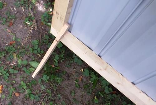 a wooden bed frame sitting in the grass