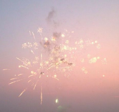 fireworks are lit up in the sky at sunset or dawn on an overcast day