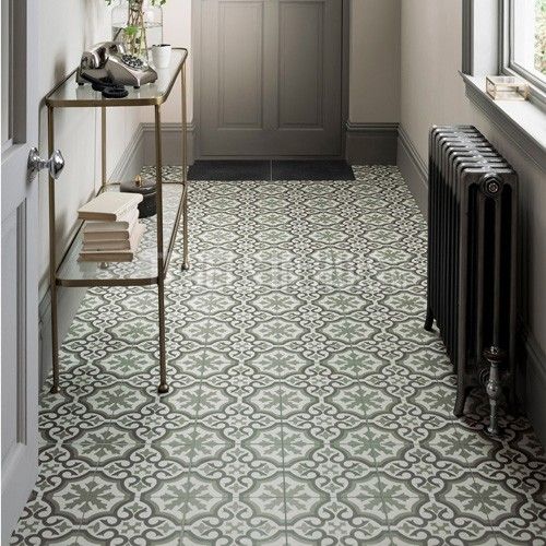 a hallway with an ornate tile floor and gray walls, along with a radiator