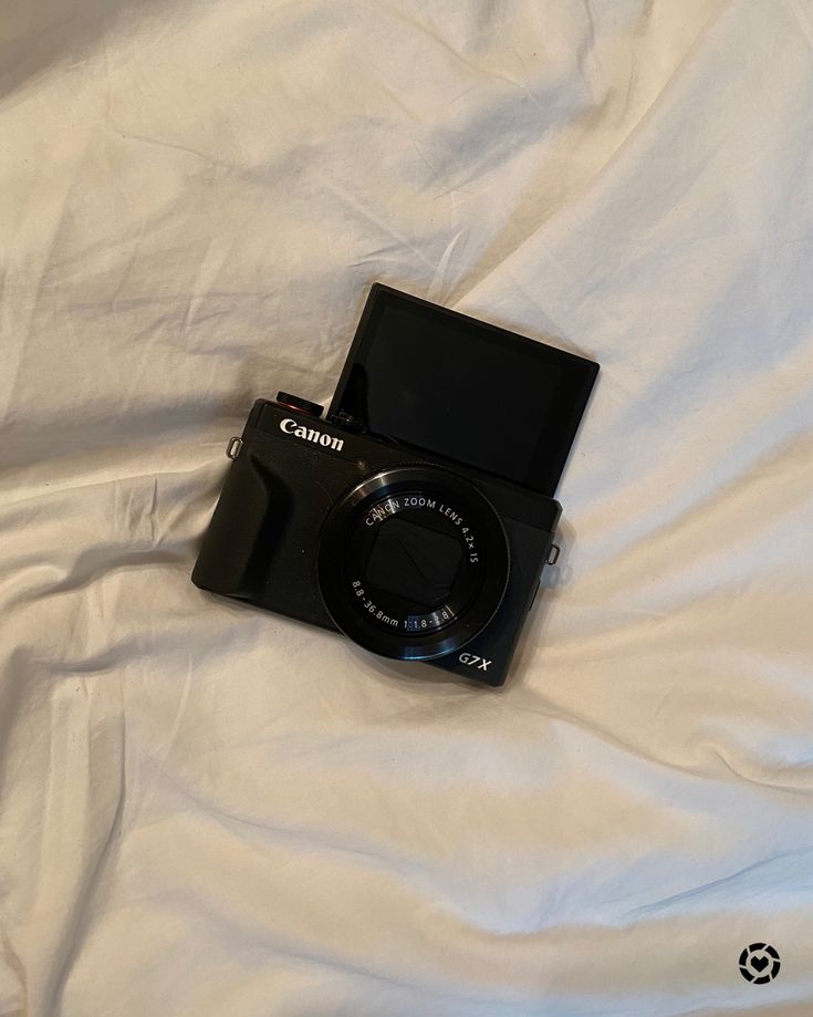 a camera sitting on top of a white sheet