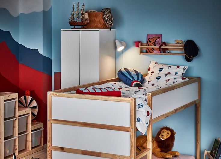 a child's bedroom with blue walls and wooden furniture