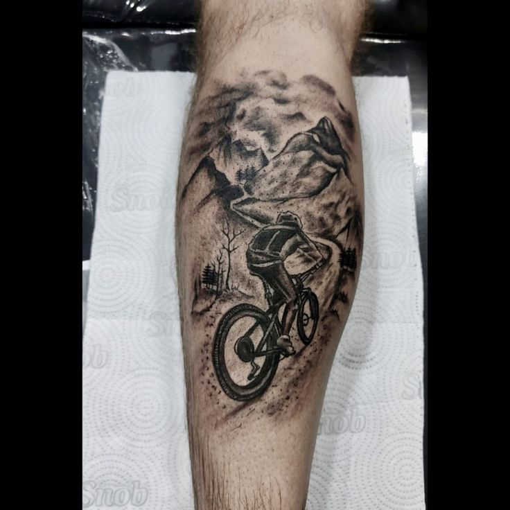 a man with a mountain bike tattoo on his leg