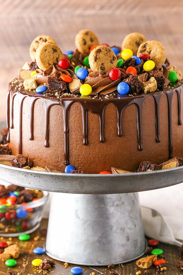 a chocolate cake topped with cookies and m & m's on top of a table