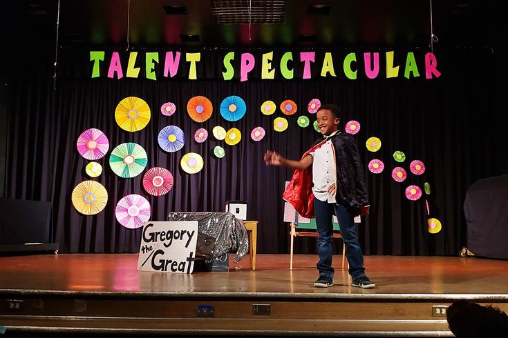 a man standing on top of a stage next to a sign that says talent spectacular