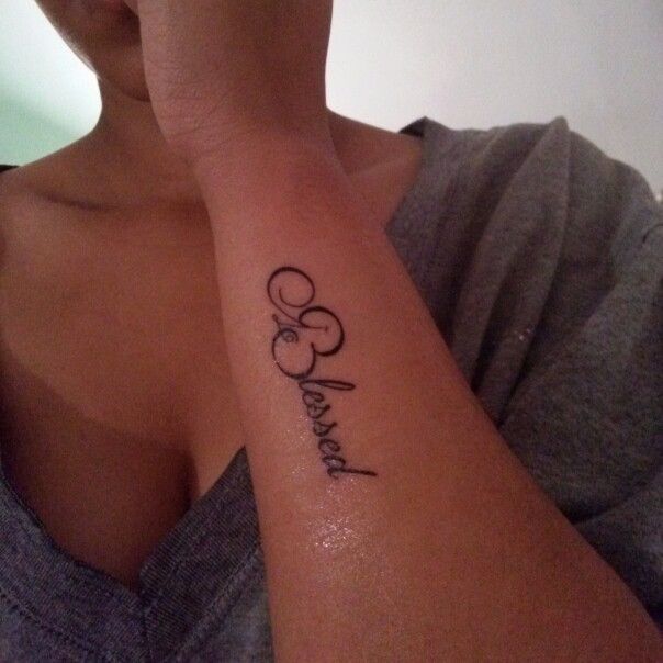 a woman with a tattoo on her arm that reads, love and faith in cursive writing