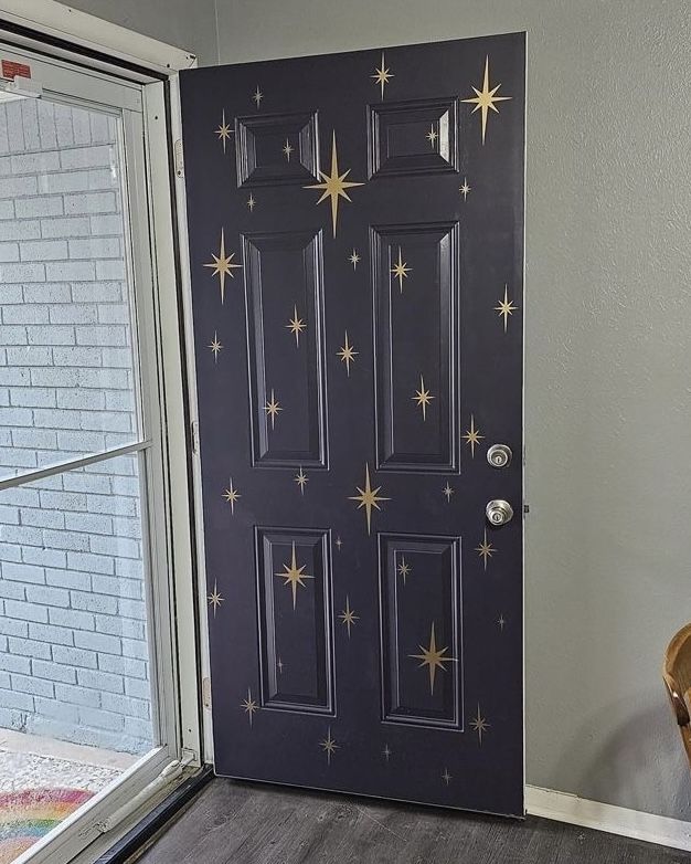 a black door with gold stars painted on it