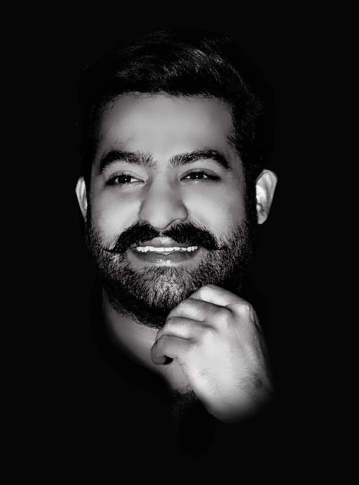 a black and white photo of a man with a goatee smiling at the camera