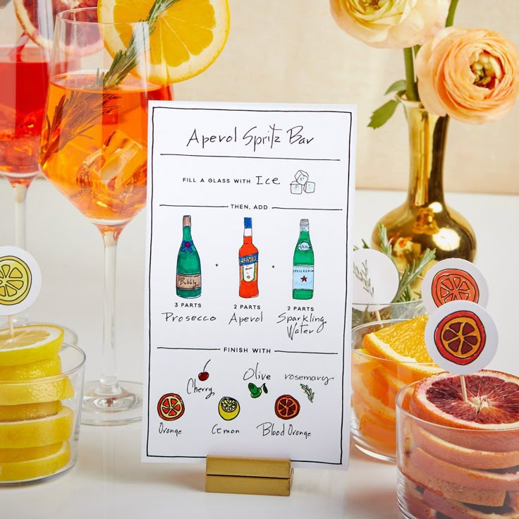 a table topped with lots of different types of drinks next to wine glasses and oranges