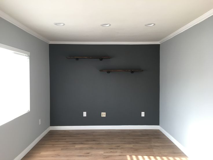 an empty room with two shelves on the wall