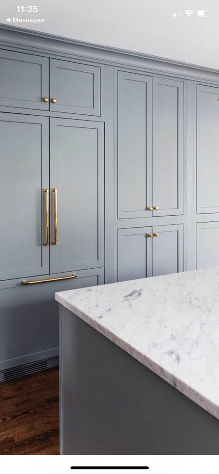 an image of a kitchen setting with marble countertops and gold pulls on the cabinets