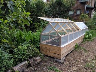 a small greenhouse in the middle of a garden