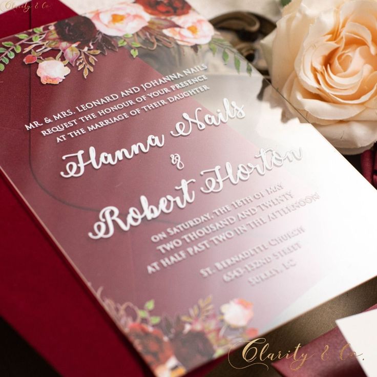 the wedding stationery is laid out on top of each other, including a rose