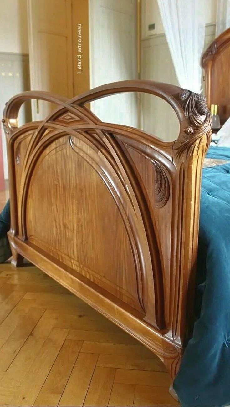 a wooden bed frame with blue sheets and pillows